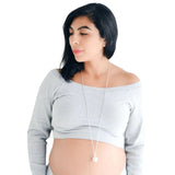 femme enceinte portant un bola de grossesse de couleur argent par le lit d'argent pour créer une connexion avec l'enfant qu'elle porte